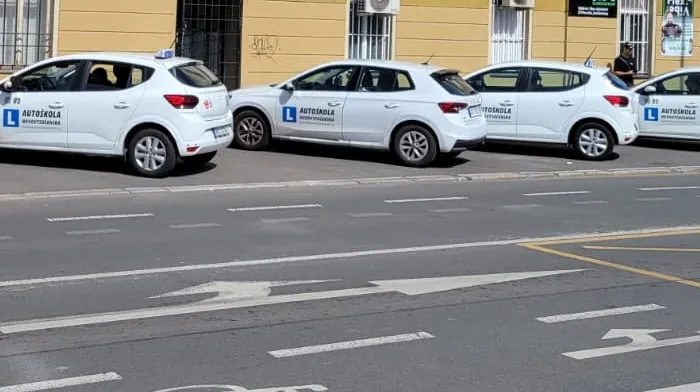 Vozy autoškoly zaparkované před budovou